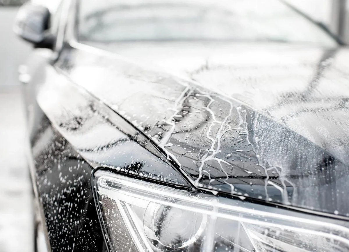 Soap and water sheeting off a car's hood with no brush marks
